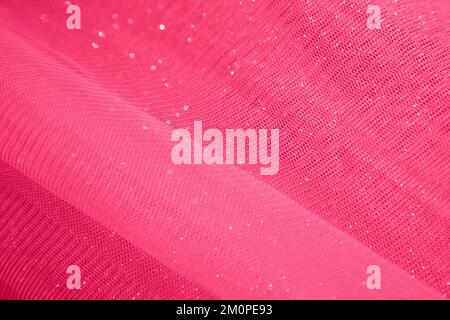 red fabric background from organza, tulle, silk. Abstract background with glitter. viva magenta Stock Photo