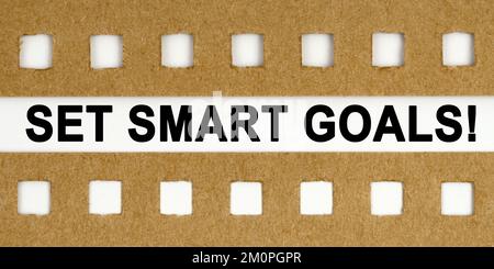 Business and economy concept. Between the sheets with holes on a white background the inscription - SET SMART GOALS Stock Photo