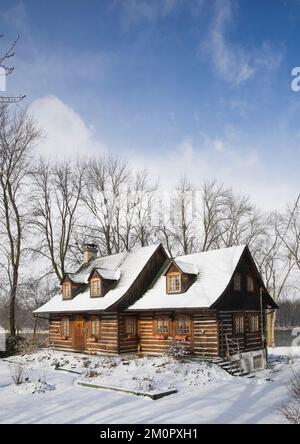 1980 built replica of old 1800s two story Canadiana cottage style log home in winter. Stock Photo