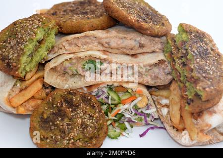 Traditional Egyptian popular breakfast street sandwiches of mashed fava beans, fried crispy falafel balls, french fries fingers and dynamite sandwich Stock Photo