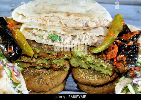 Pickled fried aubergine and green peppers, Traditional Egyptian popular breakfast street sandwiches of mashed fava beans, fried crispy falafel balls, Stock Photo