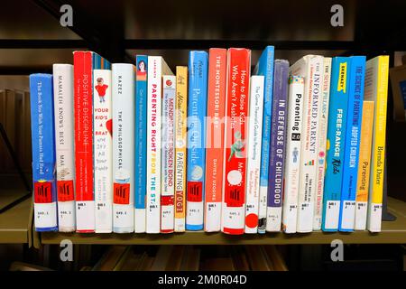 Do it yourself, self help, professional advice books on parenting and child raising on a library shelf. Stock Photo
