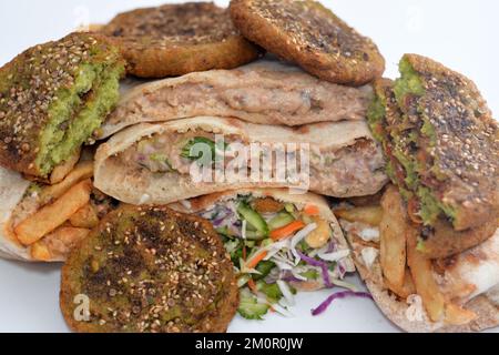 Traditional Egyptian popular breakfast street sandwiches of mashed fava beans, fried crispy falafel balls, french fries fingers and dynamite sandwich Stock Photo