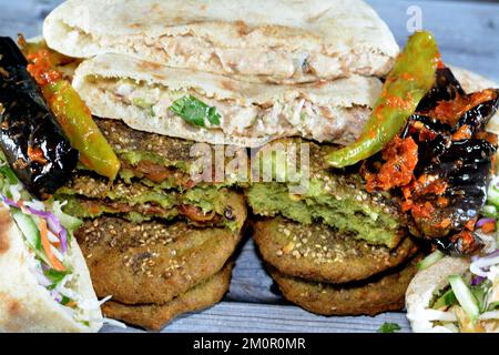 Pickled fried aubergine and green peppers, Traditional Egyptian popular breakfast street sandwiches of mashed fava beans, fried crispy falafel balls, Stock Photo