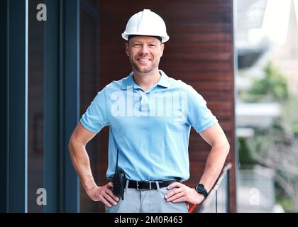Were building a future everyone can be proud of. Portrait of a cheerful engineer posing with his hands on his hips outside a building. Stock Photo