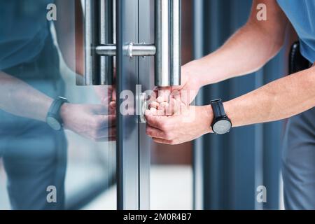 Adequate security is important in every aspect of life. an unrecognizable male locksmith installing a lock. Stock Photo