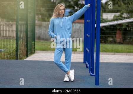 Athletic young woman posing on the sports ground outdoors Stock Photo