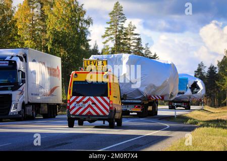 Truck gives way as two oversize load transports assisted by pilot and escort vehicles proceed on highway. Rear view. Raasepori, Finland. Sept 23, 2022 Stock Photo