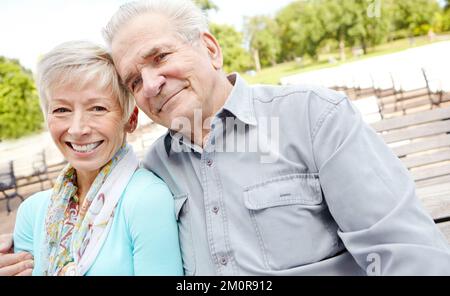 Holding her close. an elderly man putting his arm around his wife. Stock Photo