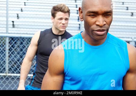 Unfazed by his opponents. Close up of two male runners wearing sports gear and preparing for the race. Stock Photo