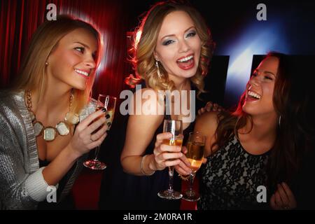Toasting their friendship. Three attractive young friends toasting with glasses of champagne while smiling at the camera. Stock Photo