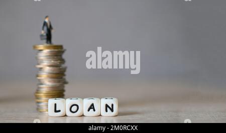 Loan business economy concept of money and finance, on table, Loan business finance economy and business man standing on a coin on wooden table backgr Stock Photo