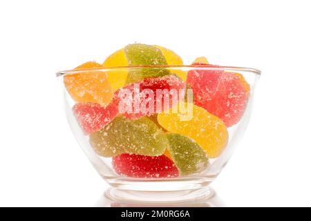 Several sweet marmalade candies in a glass plate, macro, isolated on white background. Stock Photo