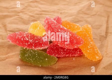 Several sweet marmalade candies on kraft paper, macro. Stock Photo