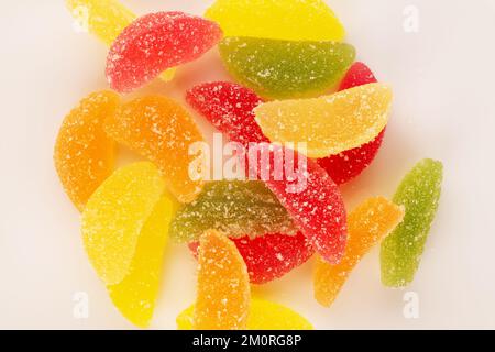 Several sweet marmalade candies on a white ceramic plate, macro, top view. Stock Photo