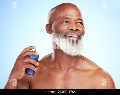 Making sure he smells his best. a handsome mature man posing in studio against a blue background. Stock Photo