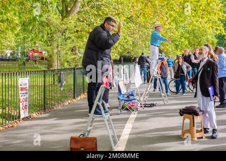 People listen to speakers at Speakers Corner in Hyde Park. London, England Stock Photo