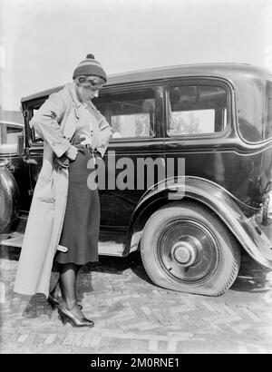 Willem van de Poll - Actress and fashion model Cissy van Bennekom near a car with a flat tyre - 1932 Stock Photo