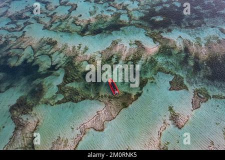 Aerial view of a red boat anchored over sand banks, Kuta Mandalika beach, Lombok, Nusa Tenggara, Indonesia Stock Photo