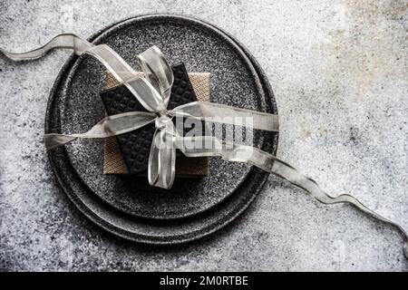 Overhead view of two gift boxes on plates tied with a silver ribbon Stock Photo