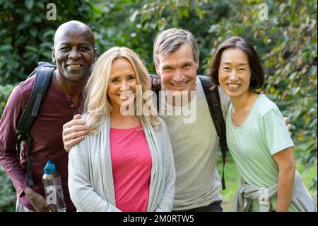Two diverse senior couples enjoying a walk out in the woods Stock Photo
