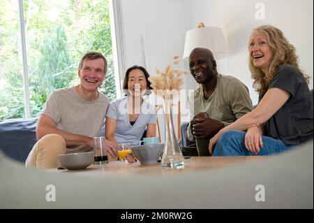 Fun diverse group of middle-aged friends having a good time at home Stock Photo