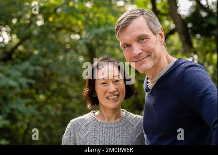 Portrtait of diverse couple lookinf at camera in public park Stock Photo