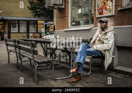 A Black male sitting in the streets Stock Photo