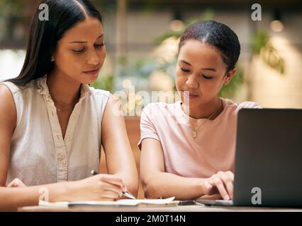 Business women with teamwork, writing and collaboration working on laptop together in the office. Business meeting, planning and strategy discussion Stock Photo