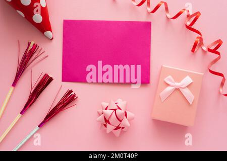 Top view of pink greeting card near gift box and serpentine on pink background,stock image Stock Photo