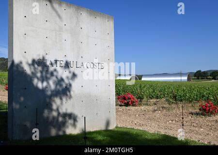 France, Bouches du Rhone, Le Puy Sainte Reparade, Chateau La Coste, Tadao Ando Art Center, Saint Gilles chapel, concrete gate designed by Japanese architect Tadao Ando at the entrance to the ch?teau vineyard La Coste, and in the background the metal cellars of Jean Nouvel (compulsory mention) Stock Photo