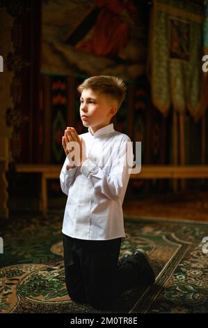 The boy is kneeling in prayer to God Stock Photo - Alamy