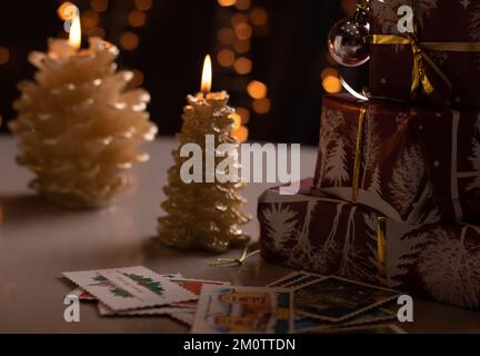 photo wrapped gifts and lit candles Stock Photo
