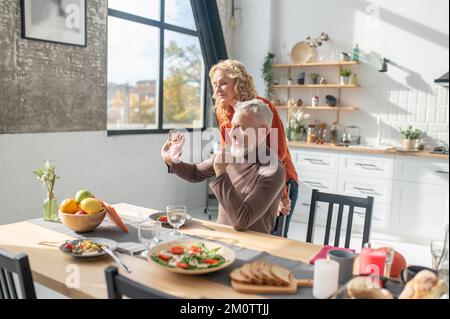 Couple looking happy and peaceful at the table in the kitchen Stock Photo