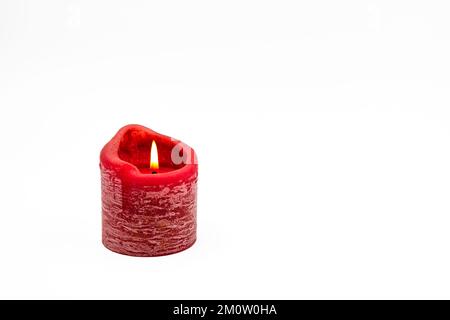 Greeting card on white background with burning red candle for Christmas and Adent as studio shot Stock Photo