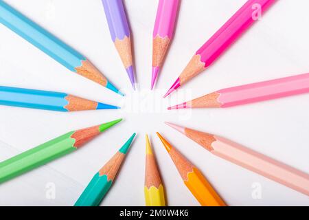 Colored pencils arranged in circle, overhead shot on white background Stock Photo