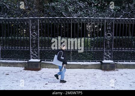 A person walks along a snow covered pavement in Holyrood Park in Edinburgh. The Met Office has issued a number of weather warnings for snow and ice for parts of Scotland, Northern Ireland, Wales and the east coast and south-west England over the coming days. Picture date: Thursday December 8, 2022. Stock Photo