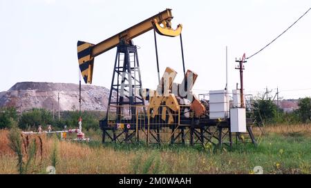 Industrial oil production industry, derrick pumps oil outdoors in the field on the oil platform. The concept of the economy, production and extraction Stock Photo