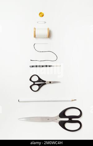 Scissors and sewing supplies on white desk. Sewing and knitting tools on white background, needlework concept. Top view on white Stock Photo