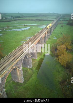 A train engine on the Harringworth rail viaduct, which crosses the river Welland between Northamptonshire and Rutland, England; with 82 arches and 20 Stock Photo