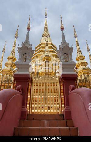 Low angle landscape view of golden stupa at landmark heritage Wat Phan Tao buddhist temple, Chiang Mai, Thailand Stock Photo