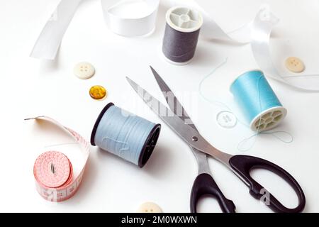 Sewing accessories for repairing clothes, layout on a white background, top view. Stock Photo