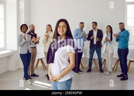 Portrait of confident happy young woman in casual clothes against background of other people. Stock Photo