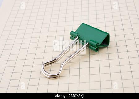Colored paper clip on a checked notebook page Stock Photo