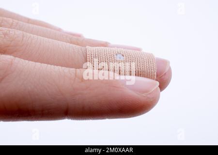 Finger in white bandage on a white background Stock Photo