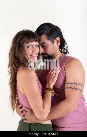 A couple is embracing each other. She is looking at the camera while he is with his eyes closed. Couple in love Stock Photo