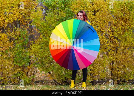 the multi-colored huge umbrella and a girl in yellow boots Stock Photo