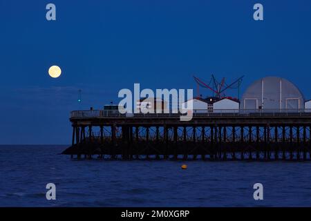 Herne Bay, Kent, UK. 8th December 2022: UK weather. Cold moon climbs into clear skies above Herne Bay pier. The last full moon of 2022. Credit: Alan Payton/Alamy Live News Stock Photo