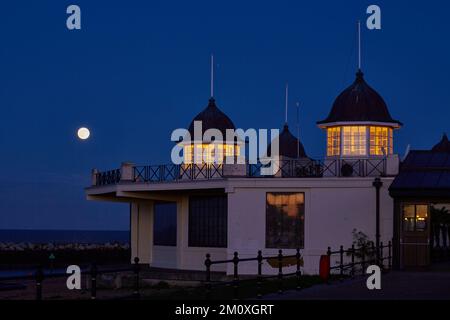 Herne Bay, Kent, UK. 8th December 2022: UK weather. Cold moon climbs into clear skies near the bandstand at Herne Bay. The last full moon of 2022. Credit: Alan Payton/Alamy Live News Stock Photo