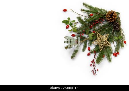 Natural floral christmas corner - rustic decoration of  green spruce, barberry twigs and wild rose fruits with golden star, flat lay, copy space Stock Photo